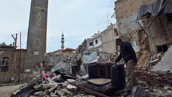 A man inspects rubble in Homs, March 2013 (photo: Reuters)