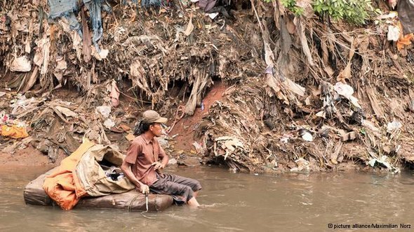 A young man looking for usable waste in the Ciliwung river (photo: dpa)