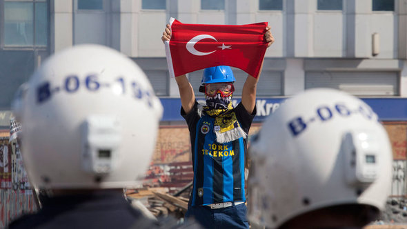 متظاهر أمام أفراد الشرطة في ميدان تقسم في اسطنبول. د ب أ  