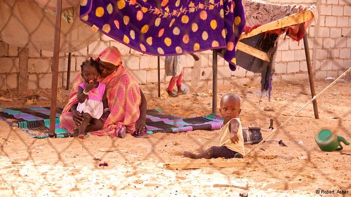 Matallah, a former slave, in her makeshift home, with two of her young children (photo: Robert Asher)