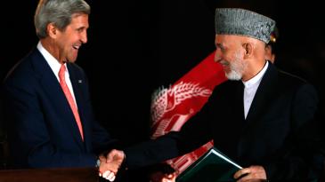 الرئيس الأفغاني كرزاي ووزير الخارجية الأمريكي كيري في كابل بعد إعلانهما نتائج الاتفاقية الأمنية بينهما في 12 أكتوبر/ تشرين الأول 2013. photo: Mohammad Ismail/Reuters 