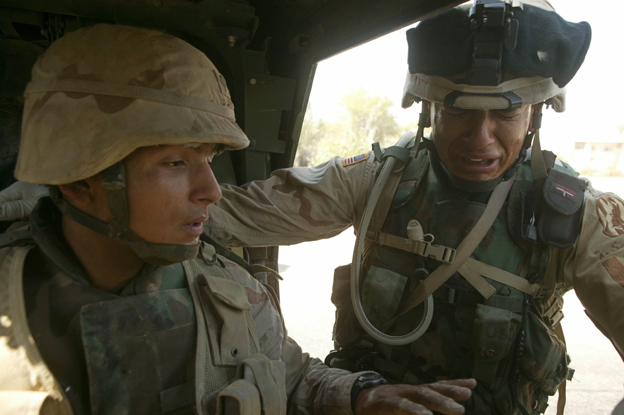 Zwei US-Soldaten betrauern den Tod eines Mitglieds aus ihrer Einheit nach einem Bombenanschlag an einer Straße in Sadr City, Bagdad; Foto: Michael Kamber