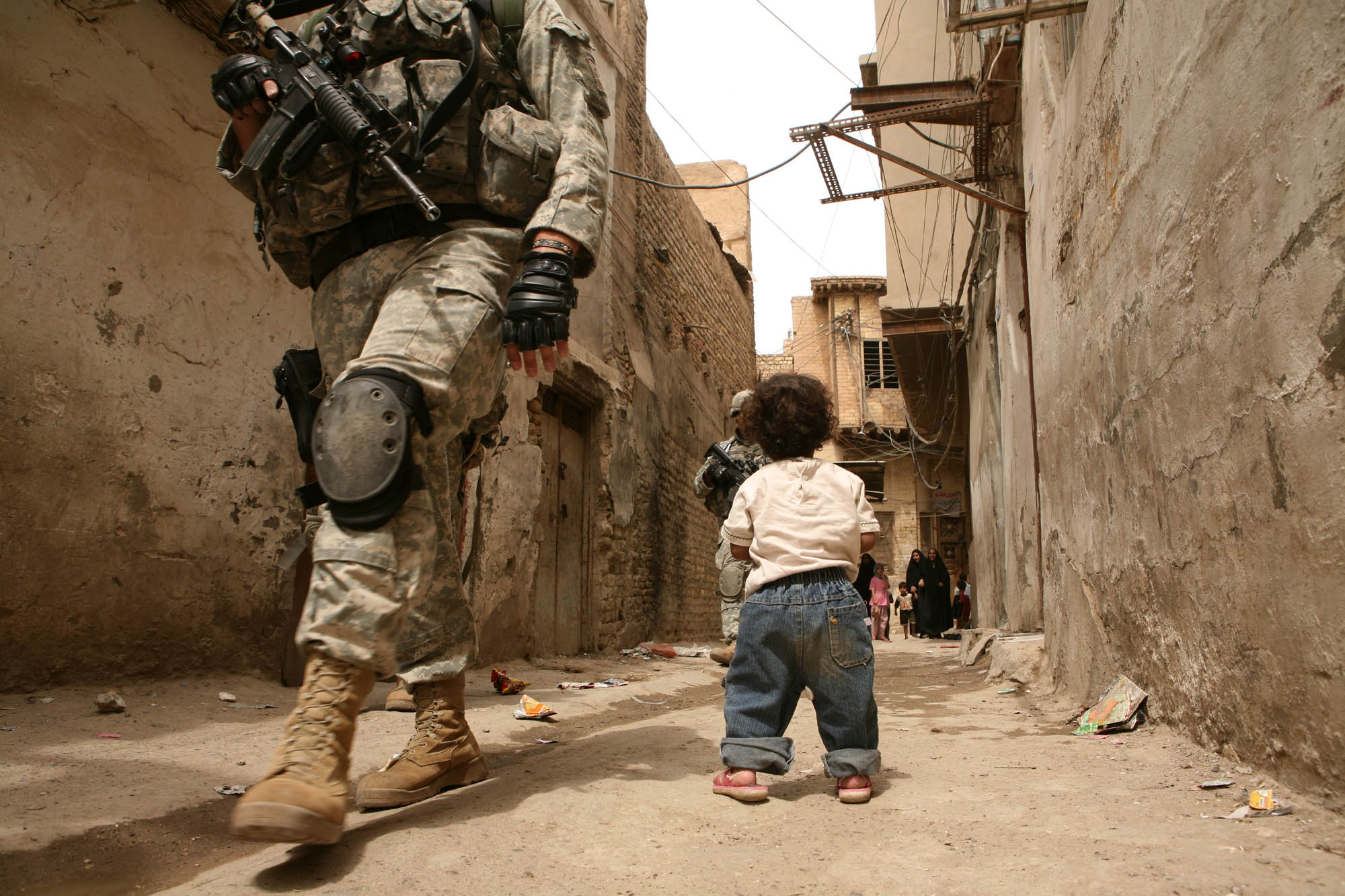 A small child watches US soldiers patrolling the streets of Khadamiya (photo: Michael Kamber)