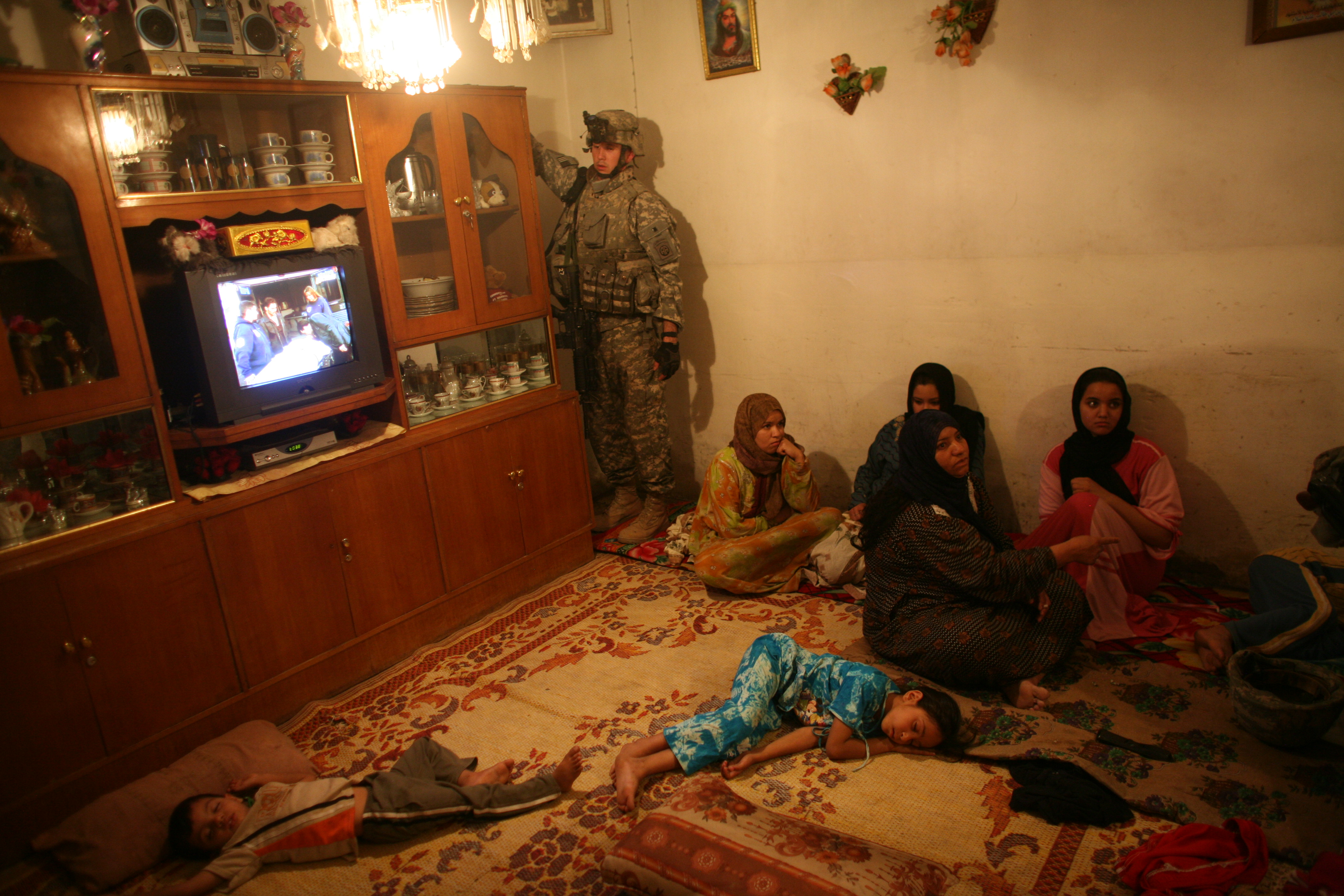 US soldiers search a home in a late-night raid as children lie asleep (photo: Michael Kamber) 