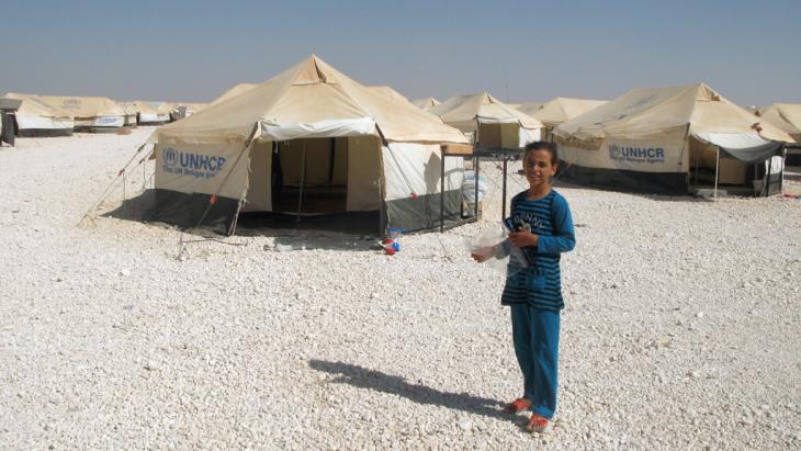 A child stands in front of UNHCR tents in the Zaatari refugee camp in Jordan (photo: picture-alliance/dpa)