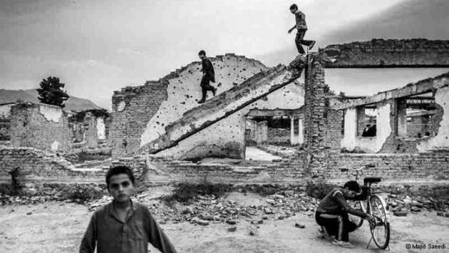 Children on and in front of ruined buildings (photo: Majid Saeedi)