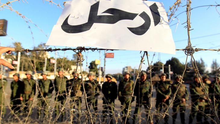 Army units stand behind barbed wire and a sign that reads "Get lost!" outside the presidential palace in Cairo in December 2012 (photo: Reuters)