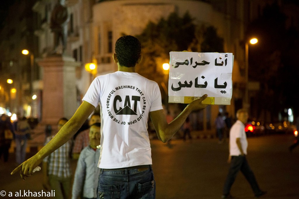 يرفع شاب لافتة وهو يبيع في منتصف في القاهرة. A. Alkhashali