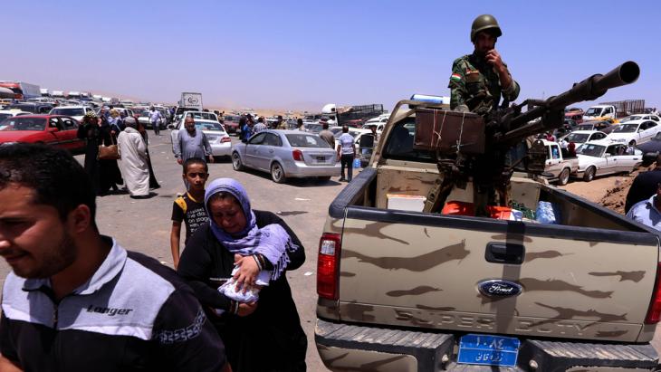 Residents of Mosul and Kurdish Peshmerga fighters at a checkpoint in Aski Kalak (photo: Safin Hamed/AFP/Getty Images)