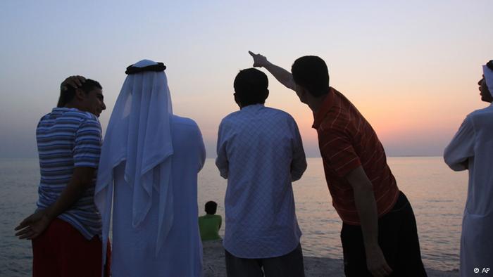 Men at the seaside in Bahrain at sunset. Photo: AP