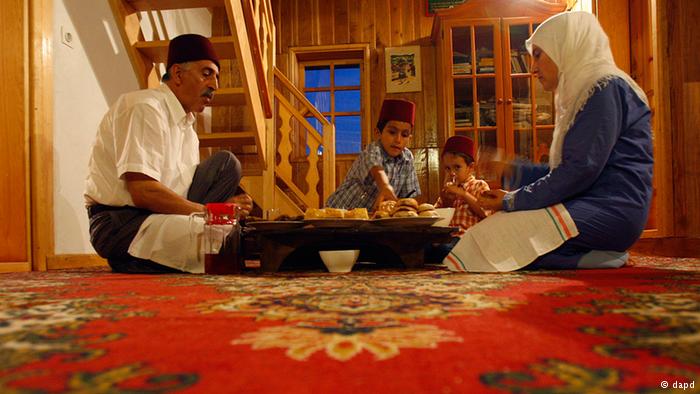 A Bosnian Muslim family sitting on the floor of their home for the Iftar meal. Photo: dapd