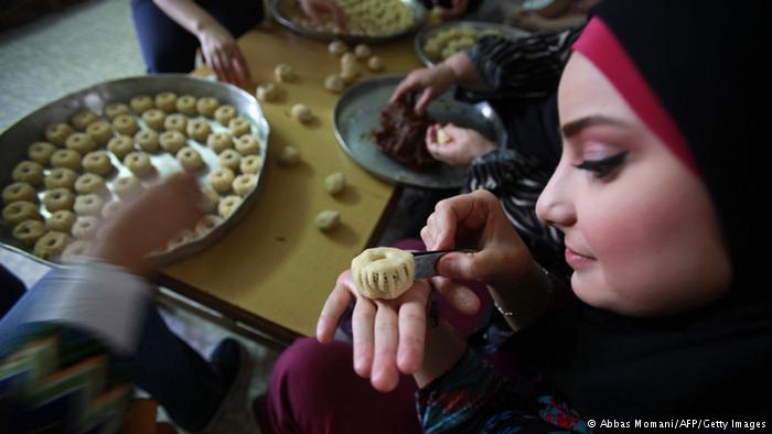 Woman in Ramallah in front of plates of sweetmeats. Photo: Abbas Momani/AFP/Getty Images