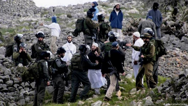 Soldiers breaking up a protest organised by settlers in February 2013 (photo: picture alliance/landov)