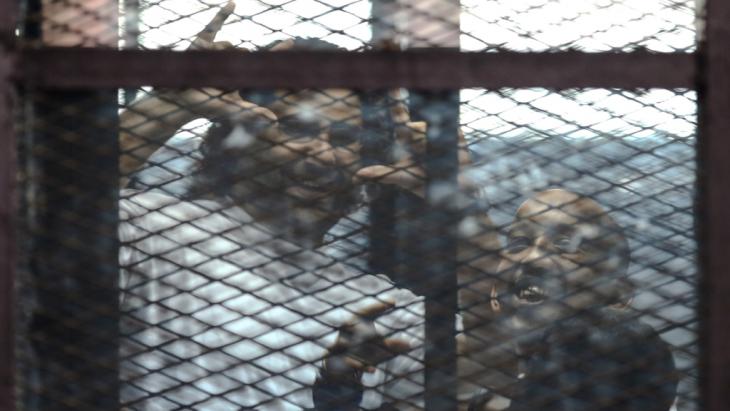 Alaa Abdel-Fattah (left) and Mohamed el-Shahed in a prisoners' cage in a Cairo courtroom (photo: Getty Images/AFP)