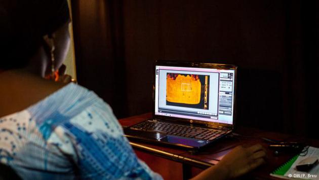 A woman looks at an image of a manuscript on a laptop screen (photo: DW/P. Breu)