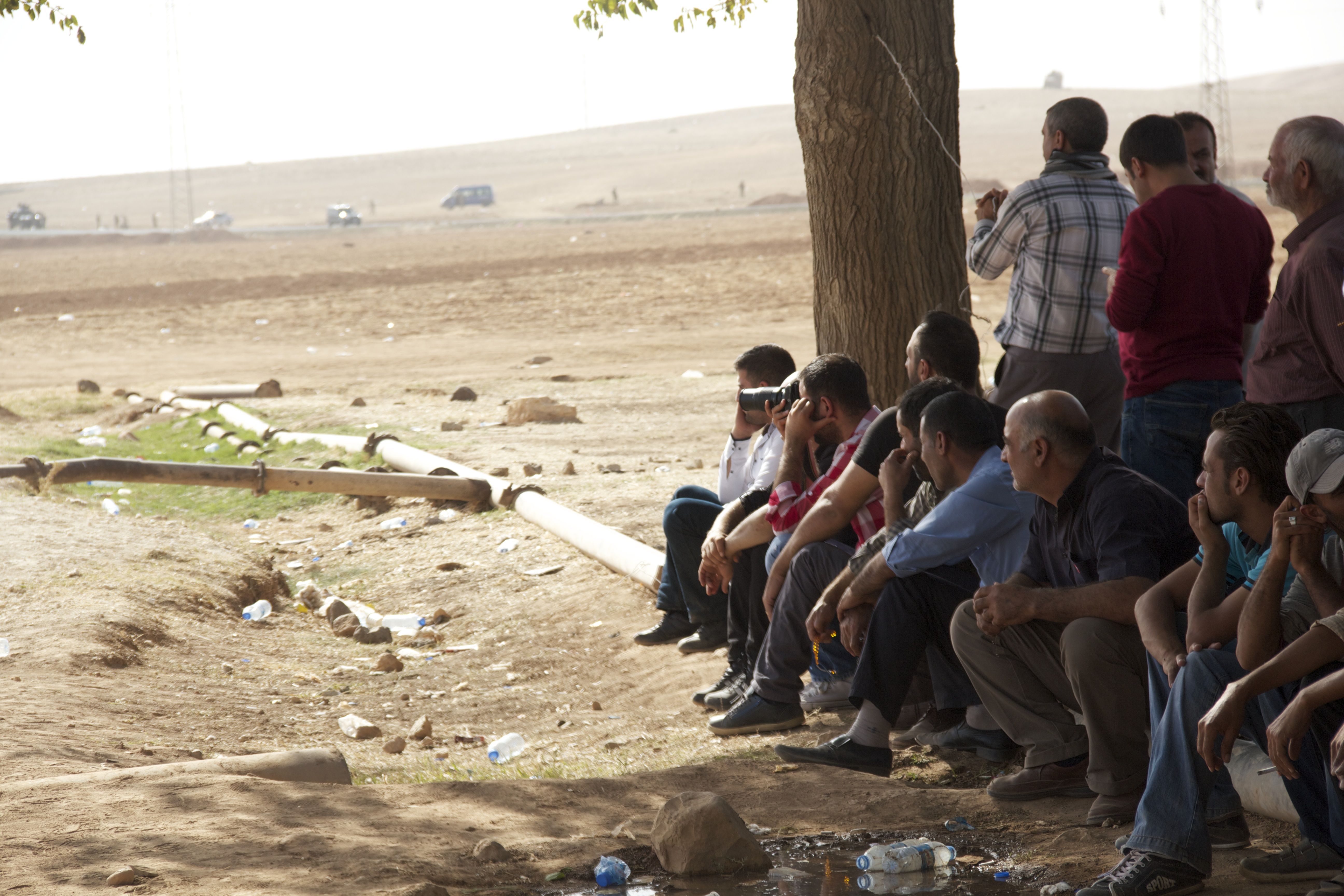 Syrian and Turkish Kurdish fighters wait at the Turkish border for their chance to cross over into Kobani (photo: Kiran Nazish)