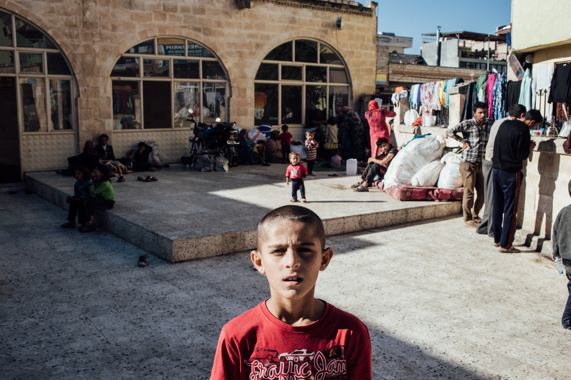 A Syrian refugee child stands outside a mosque used as a refugee camp, Suruc, Turkey, October 2014 (photo: Furkan Temir)