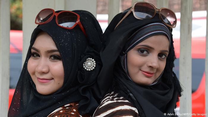متسابقة هندية وأخرى ماليزية ترتديان العباءة الخليجية.
