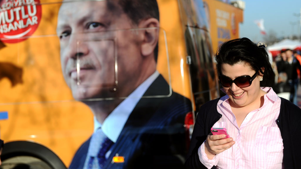 A Turkish woman in front of an image of President Erdogan (photo: OZAN KOSE/AFP/Getty Images)