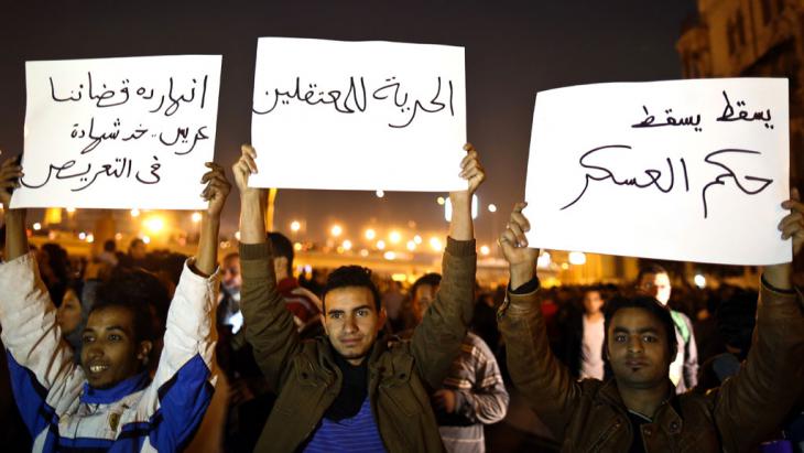 Demonstrators on Tahrir Square in Cairo holding up placards that read "down with military law" and "freedom for prisoners" (photo: MOHAMED EL-SHAHED/AFP/Getty Images)