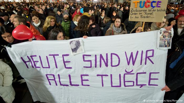 قام الأشخاص المتجمهرون أمام مستشفى سانا-كلينيكوم في مدينة أوفنباخ الألمانية حيث كانت ترقد توتشه برفع لافتات كتبوا عليها "كلنا اليوم توتشه".