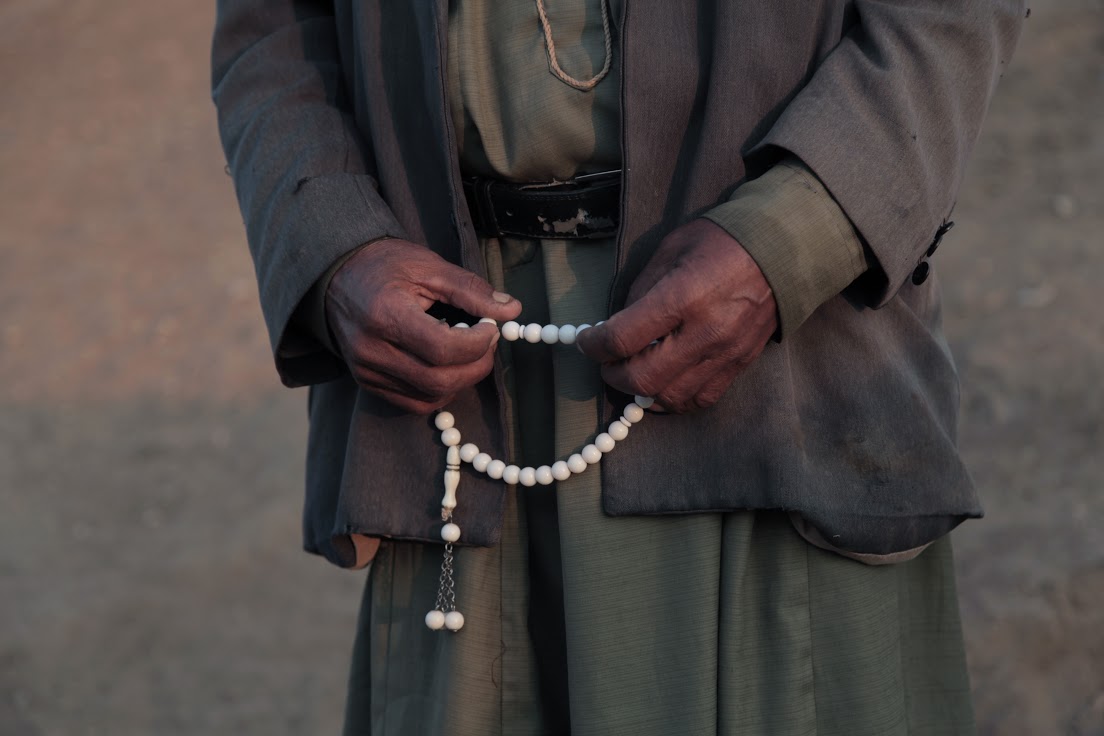 Ehmaid Kaabneh holds his prayer beads as he tends his sheep, Al-Maleh, West Bank, October 2014 (photo: Mohammad Alhaj) 