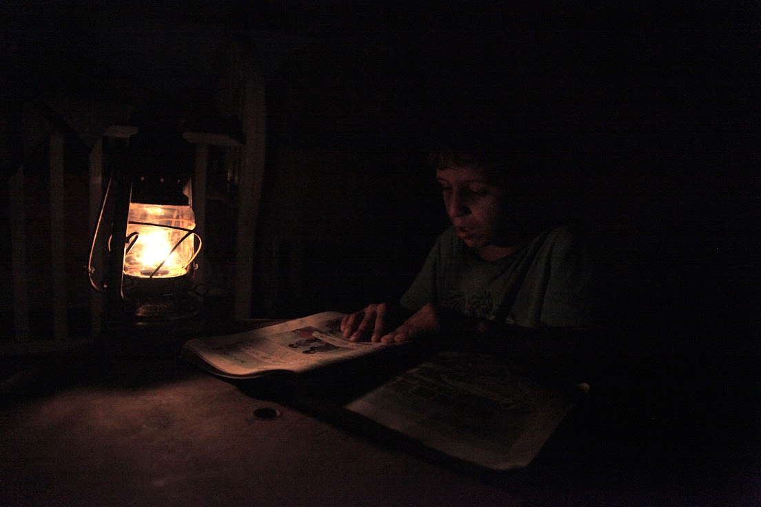 A Bedouin boy does his homework by lamp light, near Tubas, West Bank, October 2014 (photo: Mohammad Alhaj)