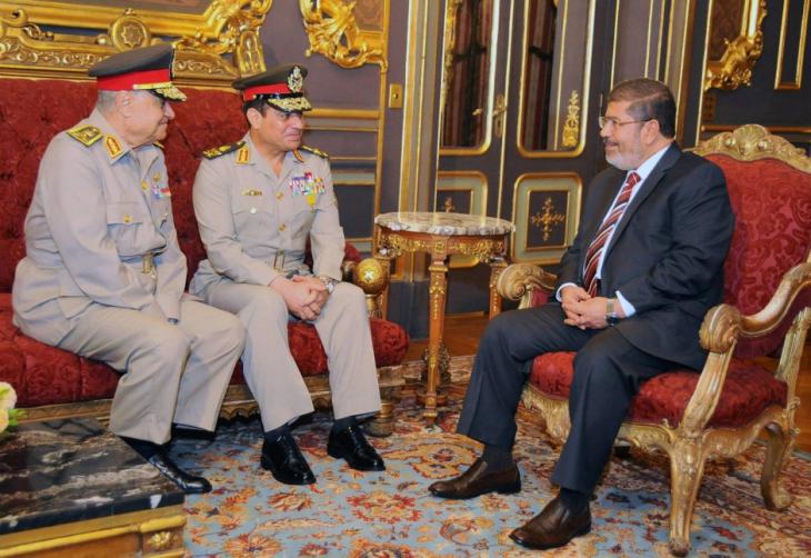 Former Egyptian President, Mohammed Morsi (right), talking to two senior members of the army, including former defence minister and current president, Abdul Fattah al-Sisi (centre) in December 2012 (photo: dpa)
