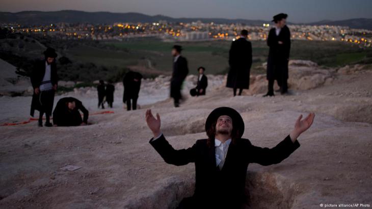 An ultra-Orthodox Jewish man raises his hands during a protest against construction of a new housing project at a site that protesters claim contains ancient graves in Beit Shemesh, Israel, February 2014 (photo: picture-alliance/AP Photo)