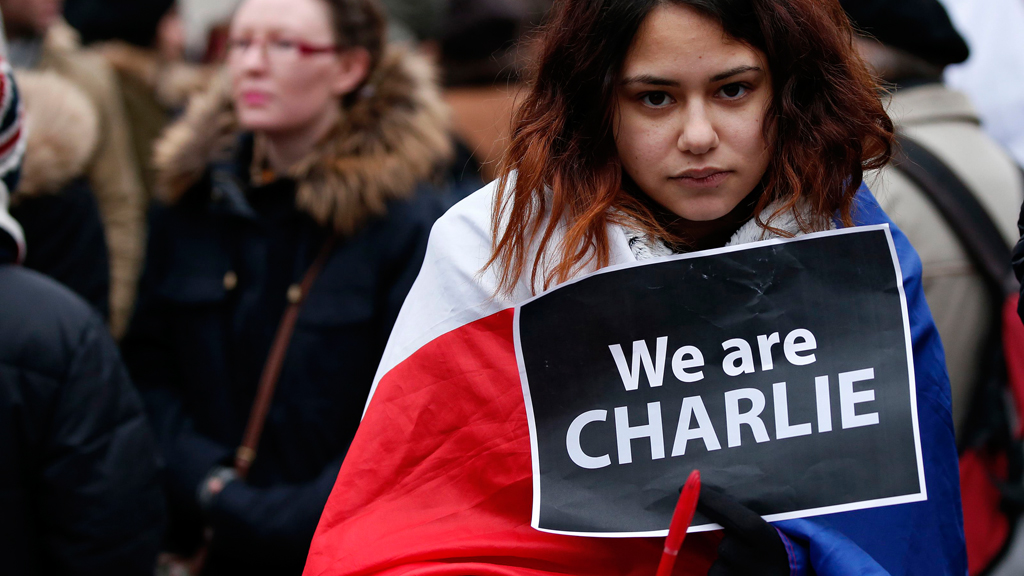A woman wearing a French tricolour holds a "We are Charlie" sign during a march for the victims of the shootings in Liverpool, northern England, 11 January 2015 (photo: Reuters/Noble)
