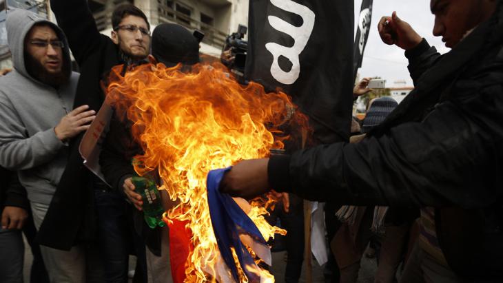 Militant Salafists and supporters of IS burning the French tricolour (photo: Reuters)