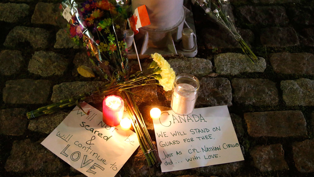 Flowers and candles left by mourners at the National War Memorial in Ottawa, Canada, after a soldier was killed by Michael Zehaf-Bibeau, a Canadian citizen and convert to Islam, on Wednesday, 22 October 2014 (photo: AP Photo/The Canadian Press, Patrick Doyle)