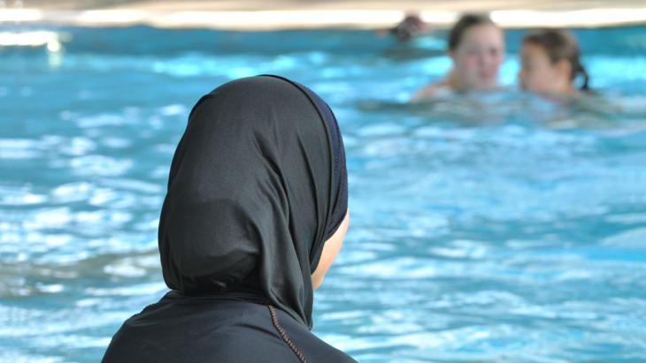 A young Muslim woman in a burkini in a public swimming pool (photo: picture-alliance/dpa/Rolf Haid)