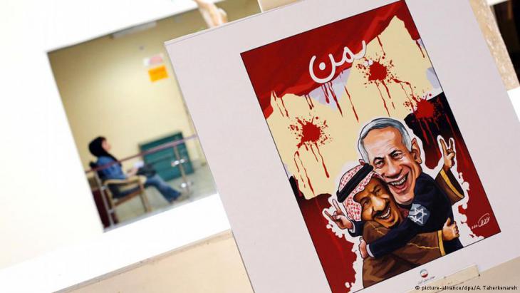 Cartoon showing Benjamin Netanyahu hugging King Salman in front of a map of Yemen (photo: picture-alliance/dpa/A. Taherkenareh)