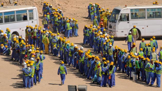 Foreign workers queuing for buses (photo: picture-alliance/dpa)