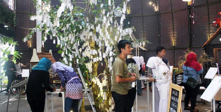 Visitors at Yoko Ono's "Wish Tree" at "Artjog" 2015 (photo: Christina Schott)