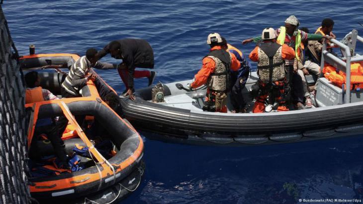 German soldiers pulling refugees from an inflatable boat near Lampedusa (photo: Bundeswehr/PAO Mittelmeer/dpa)