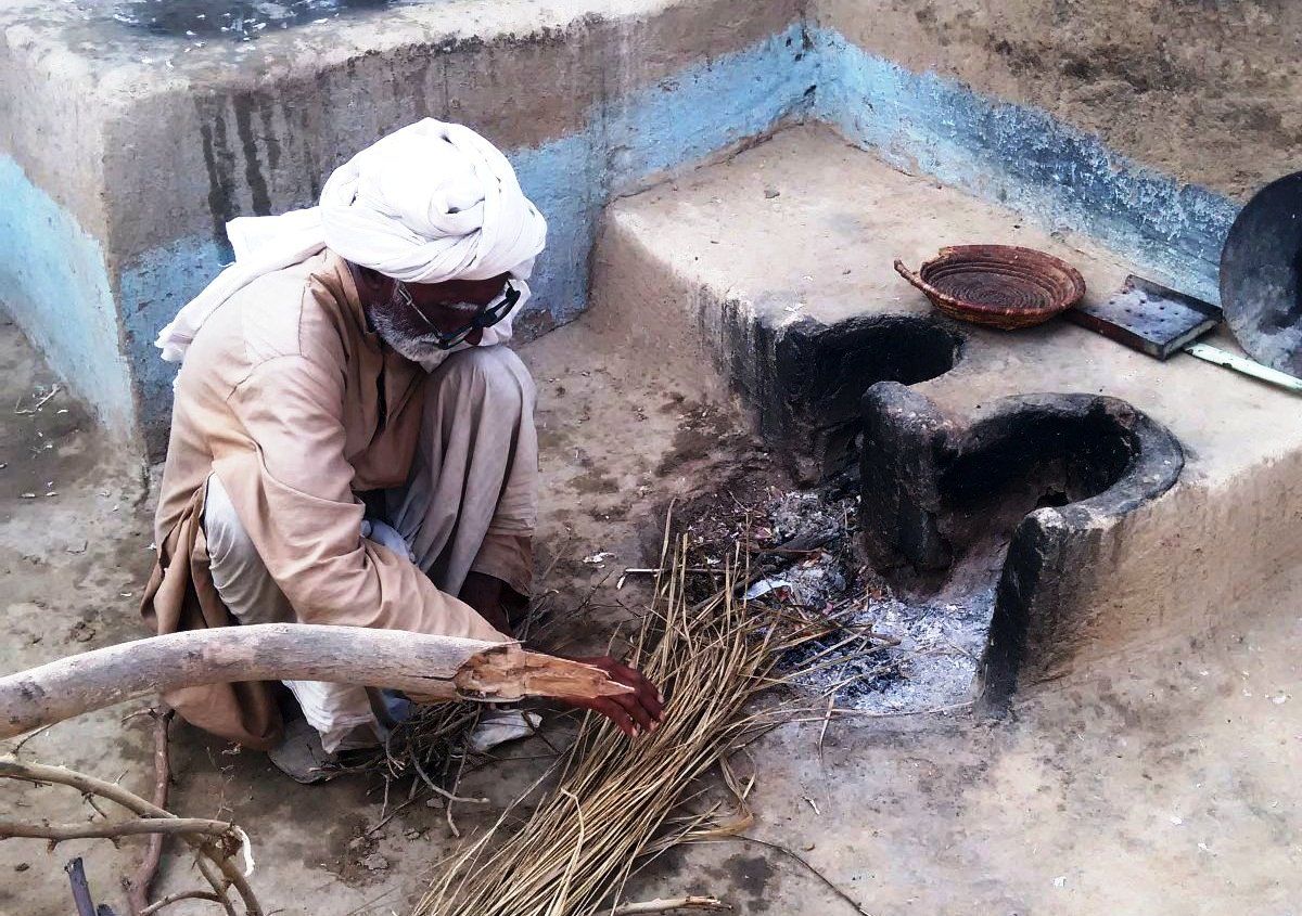 Ein älterer Mann zündet das Feuer an. Foto: Usman Mahar