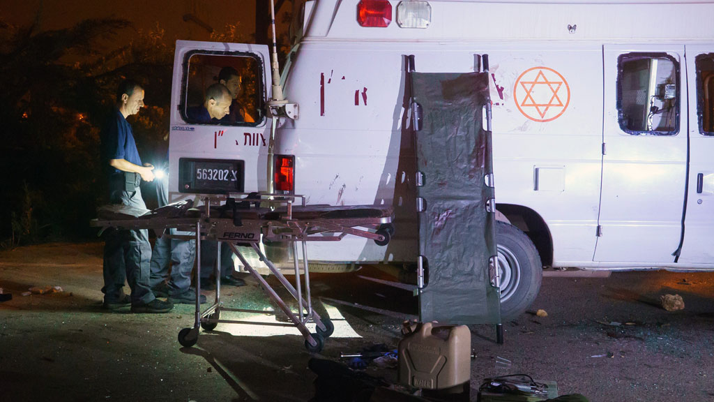 Israelisches Sicherheitspersonal überprüft einen israelischen Militärkrankenwagen, der in der israelischen Siedlung Neve Ativ in der Nähe von Majdal Shams von israelischen Drusen angegriffen wurde. Der Wagen war am 22. Juni 2015 mit zwei verletzten Syrern auf dem Weg zu einem Krankenhaus; Foto: STR/AFP/Getty Images