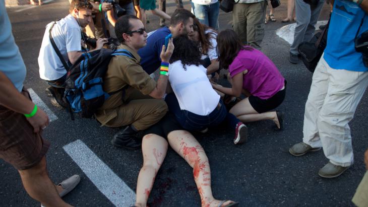 People rush to the aid of the victim of a knife attack on the Gay Pride Parade in Jerusalem, 30 July 2015 (photo: Getty Images/L. Mizrahi)