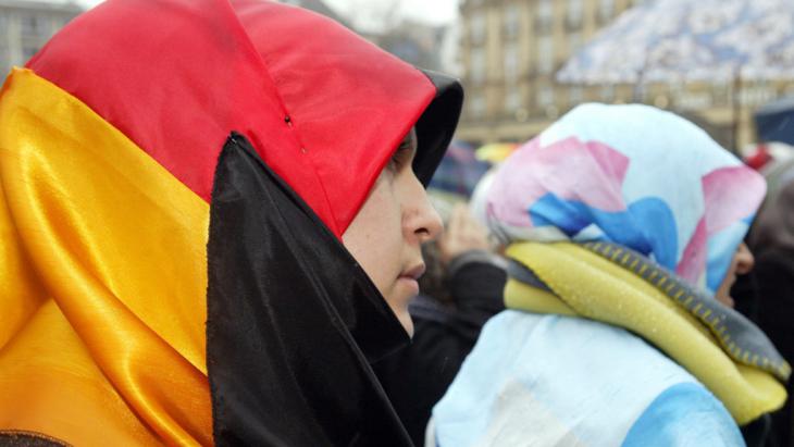 A woman wears a German flag as a headscarf at a demonstration against the ban on headscarves and "pseudo press freedom" in Germany (photo: picture-alliance/dpa)