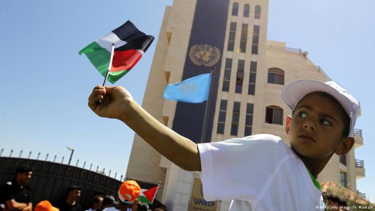 A Palestinian boy waves the national flag in front of the UN office in Ramallah (photo: AFP/Getty Images)