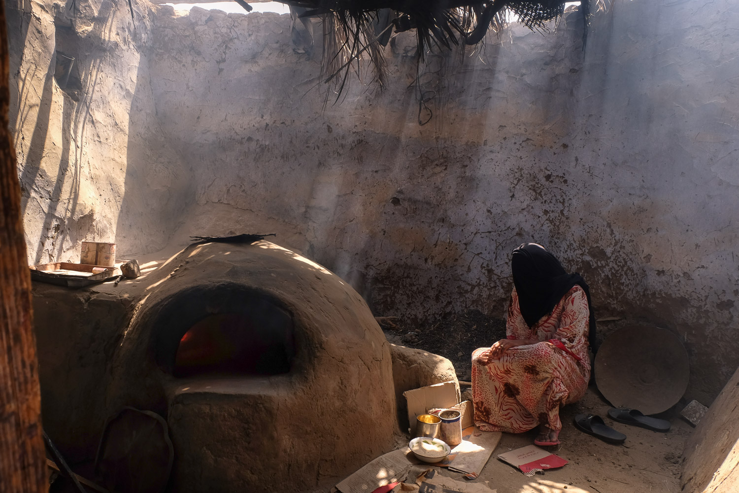 A woman on Suheil Island bakes loaves of bread in her communal outdoor kitchen (photo: Maya Hautefeuille)