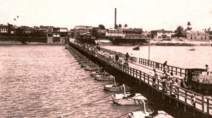 جسر الأئمة عام 1939، كان يُحمَل على زوارق ويصل بين منطقتي الكاظمية والأعظمية. حقوق الصورة: http://www.blackwhite.alnomrosi.net/Iraq/Baghdad/Baghdad100.htm و   https://ar.wikipedia.org/wiki/ملف:جسر_الأئمة_1939.jpg
