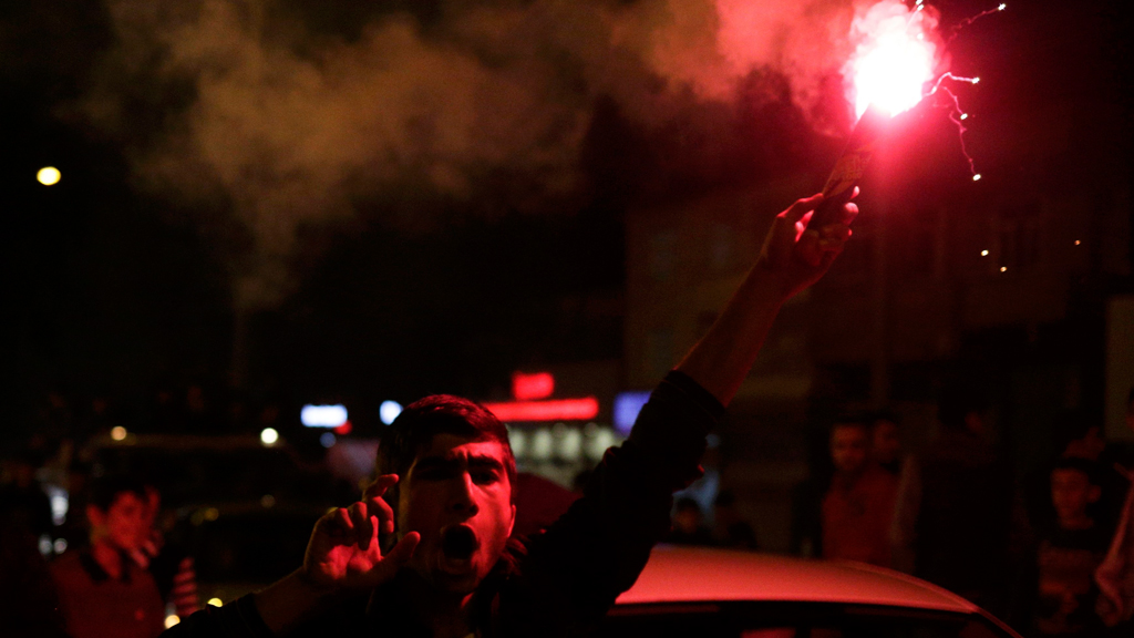 A man burns a flare outside the headquarters of Turkey's pro-Kurdish HDP opposition party in Diyarbakir on 1 November 2015 (photo: Reuters/S. Nenov)