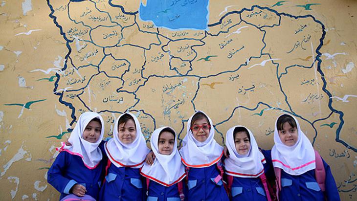 Iranian schoolgirls pose in front of a map of Iran (photo: MEHR)