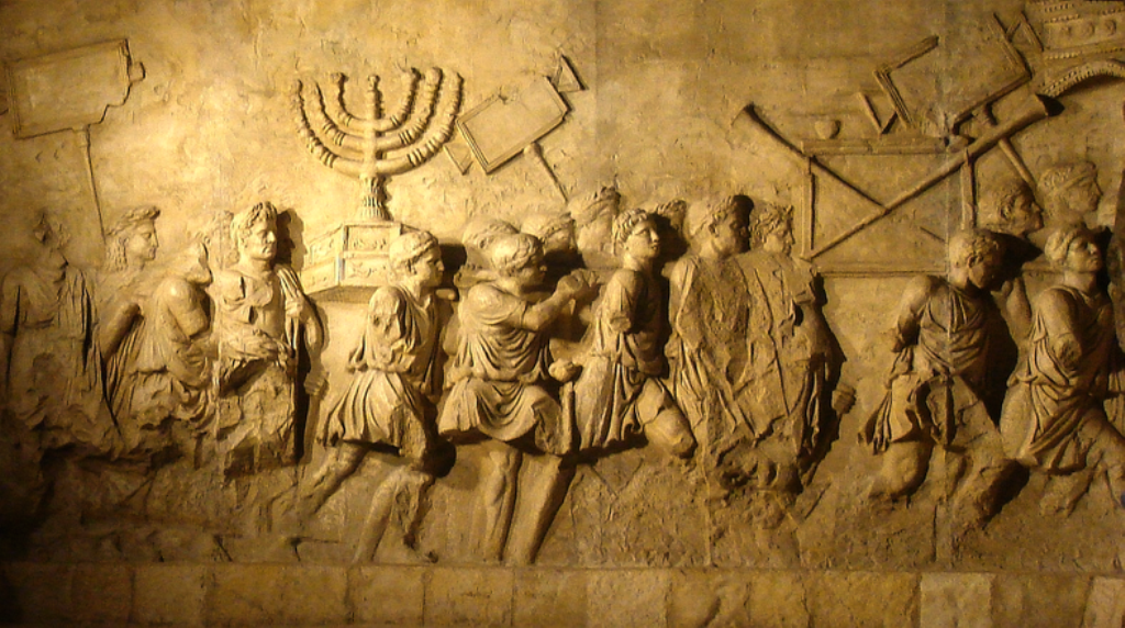 "غنائم حرب" من ضمنها الشمعدان اليهودي: نقش جداري قديم موجود في روما. المصدر: ويكيبيديا arch_of_titus_menorah