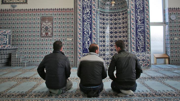 Syrian refugees Sharif Baraa, Jarkas Anas, Mohammad Amin (r-l) praying in the Ditib Mosque in Cologne Chorweiler on 15.09.2015 (photo: picture-alliance)