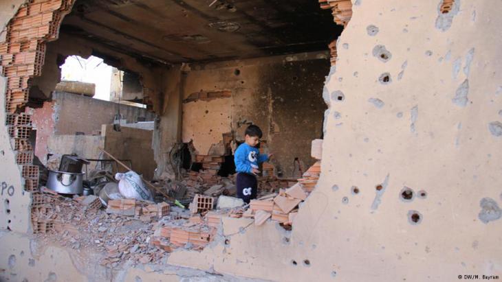 A Kurdish child in a house destroyed by the fighting (photo: DW)
