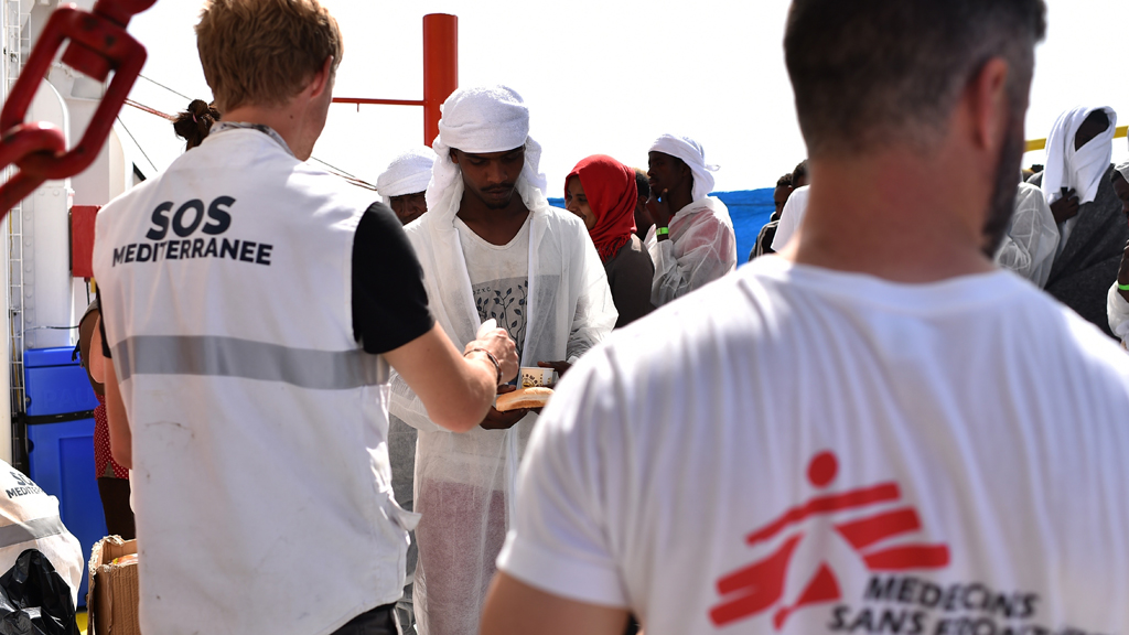 Medecins Sans Frontieres and SOS Mediteranee workers distribute food among refugees aboard the rescue ship Aquarius off the Libyan coast, 25.05.2016 (photo: GABRIEL BOUYS/AFP/Getty Images)